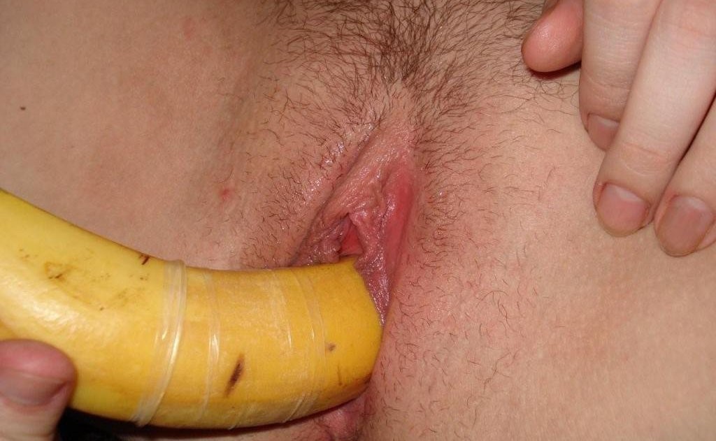 Мастурбирует бананом в презервативе